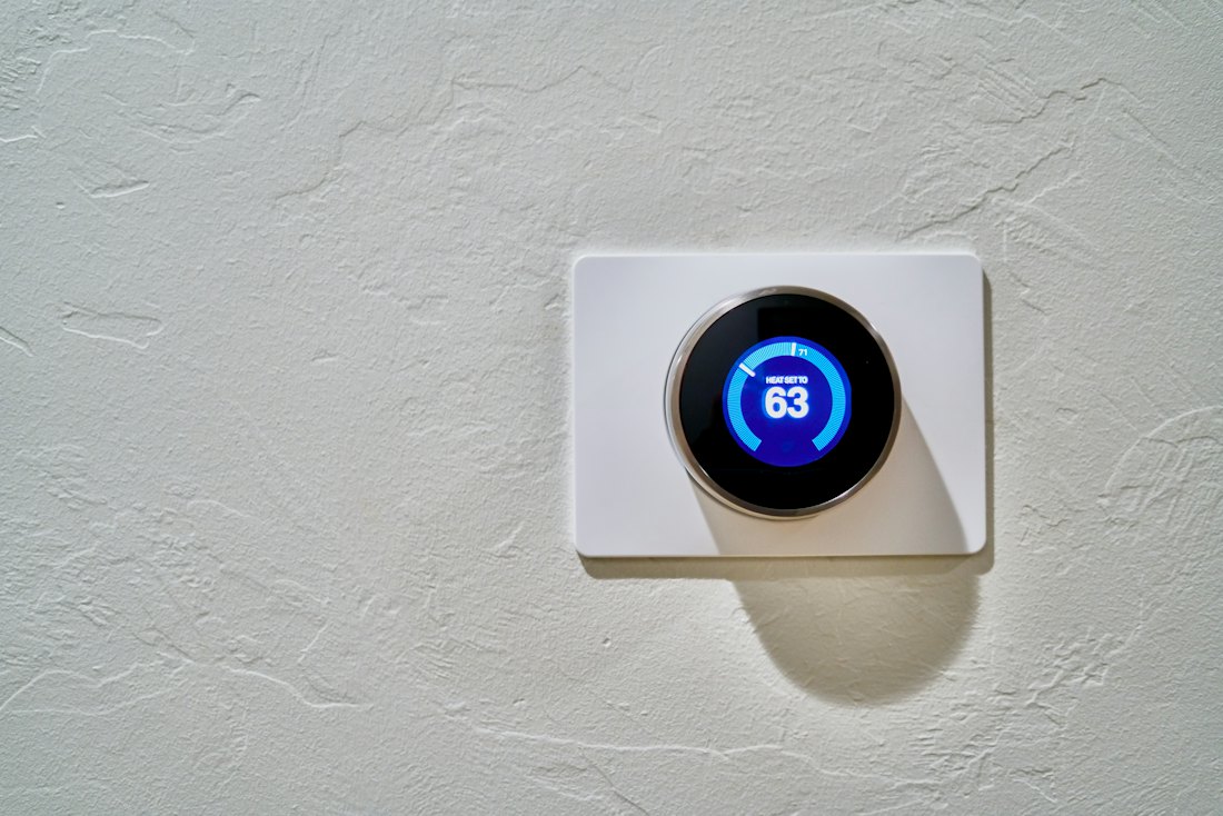 Round smart thermostat on a white wall